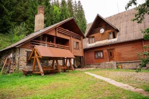 a large wooden house with a porch in front of it at River Side Retreat in Slavske