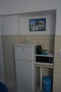 uma pequena cozinha com frigorífico e micro-ondas em Cosy Apartment Pinotsi em Atenas