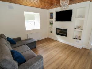 a living room with a couch and a flat screen tv at Greenfield House in Aghavas