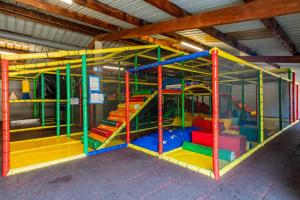 a playground with colorful play equipment in a building at Le Cocon de Galaure in Châteauneuf-de-Galaure