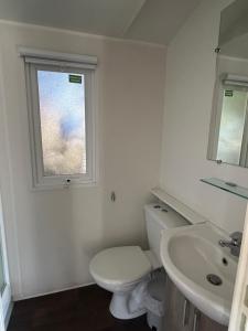 a bathroom with a toilet and a sink and a window at Le Cocon de Galaure in Châteauneuf-de-Galaure +5 photos