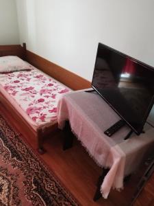 a laptop computer sitting on a table next to a bed at Casa Hirta in Ocna Şugatag