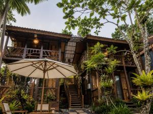 an umbrella sitting in front of a building at The Campuhan Retreat in Munggu +4 photos