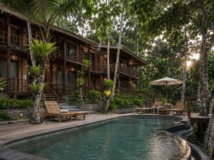 a resort with a pool in front of a building at The Campuhan Retreat in Munggu