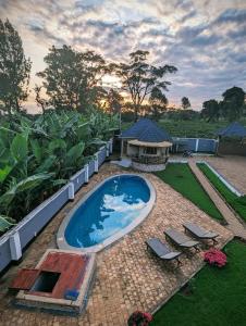 a swimming pool with two chairs and a gazebo at Dual Mountain View Lodge in Moshi