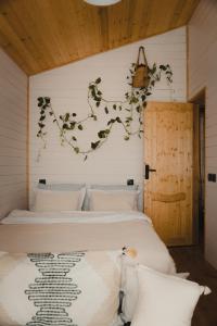 a bedroom with a bed with a branch on the wall at Haiku Cottages in Merisi