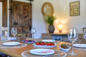 a wooden table with plates of food and wine glasses at Country home Lagom in Zagorska Sela