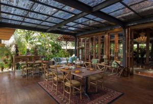 an outdoor patio with a table and chairs at Villa Canggu by Plataran in Canggu