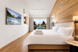 a bedroom with a large white bed and a large window at Alp Studios Apartment 2 in Wanaka +32 photos