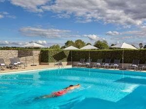 a person laying in a swimming pool at Mercure Chantilly Resort & Conventions in Chantilly