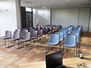 a room with a row of chairs and a laptop at ibis budget Gonesse Le Bourget in Gonesse