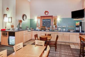 a restaurant with tables and chairs and a kitchen at AmericInn by Wyndham Douglas/Saugatuck in Saugatuck