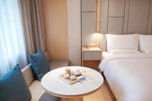 a hotel room with a bed and a table with a bed at JI Hotel Shanghai Stadium in Shanghai +30 photos