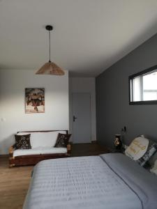 a bedroom with a large bed and a couch at Au domaine Isabelle in Lorgues +8 photos