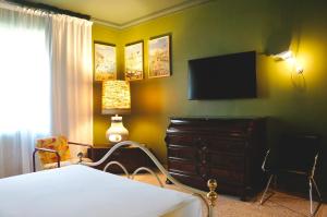 a bedroom with a bed and a dresser and a television at Kiwi in Latina