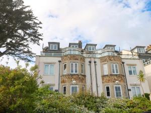 a large stone building with trees in front of it at Ocean Gem in Carbis Bay