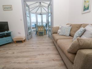 a living room with a couch and a television at Ocean Gem in Carbis Bay