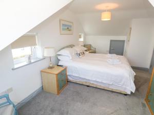 a bedroom with a large white bed and a window at Ocean Gem in Carbis Bay