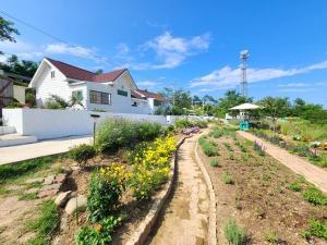 a garden in front of a house with flowers at Goseong Maris Pension in Goseong