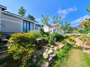 a garden with rocks and plants in front of a house at Goseong Maris Pension in Goseong