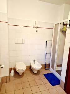 a bathroom with a toilet and a sink at Bernina Stop & Go apartment - 30 steps to the red train in Tirano +5 photos