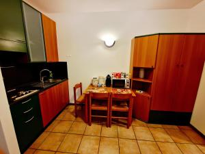 a kitchen with a small table with a microwave at Bernina Stop & Go apartment - 30 steps to the red train in Tirano