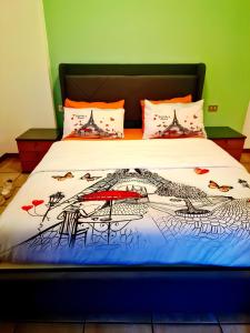 a bed with a bedspread with a painting on it at Bernina Stop & Go apartment - 30 steps to the red train in Tirano