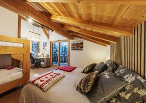 a bedroom with a large bed in a room with wooden ceilings at Chalet Arpitan - les Carroz - Grand Massif in Les Carroz d'Araches