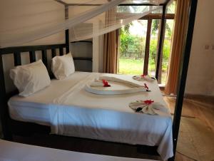 a bedroom with a bed with red flowers on it at Tropinest bungalows & hostel in Nungwi