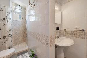 a white bathroom with a sink and a shower at Stella Del Sud in Squinzano