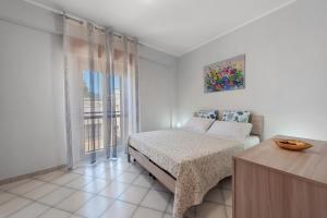 a white bedroom with a bed and a window at Stella Del Sud in Squinzano