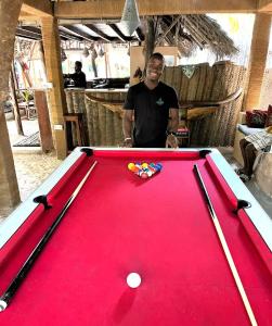 a man standing in front of a pool table at Demani Lodge Zanzibar in Paje