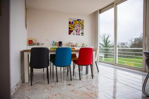 a kitchen with a table with four colorful chairs at Villa Bianca in Dalhem