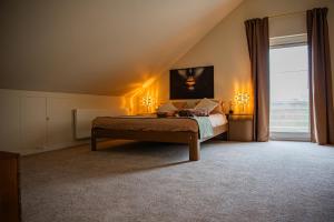 a bedroom with a bed with two lamps and a window at Villa Bianca in Dalhem