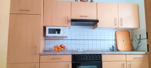 a kitchen with wooden cabinets and fruit on the counter at Waldblick Nordhorn in Nordhorn