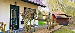 a house with a green door and a small shed at Waldblick Nordhorn in Nordhorn