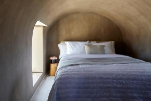 a bedroom with a large bed in a room at Santorini Sky, The Lodge in Pyrgos