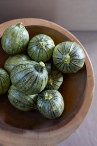 a bowl full of green vegetables on a table at Santorini Sky, The Lodge in Pyrgos