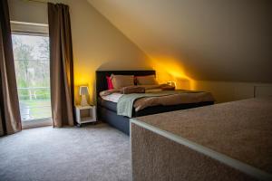 a bedroom with a bed and a large window at Villa Bianca in Dalhem +9 photos