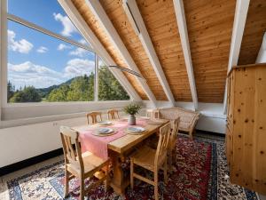 a dining room with a table and chairs and a large window at Bergzauber am Semmering in Semmering