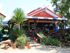 a building with a red roof and some plants at Na Chan Resort in Ban Khlong Khlung (1)