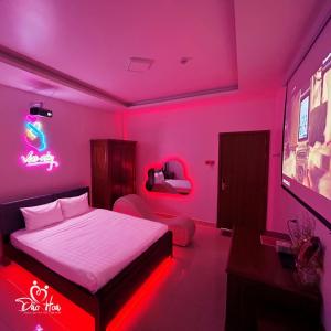 a pink room with a bed and a tv at Đào Hoa Mộng Couple Hotel - Central & City View in Quy Nhon