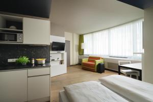 a hotel room with a kitchen and a living room at harry's home Wien hotel & apartments in Vienna