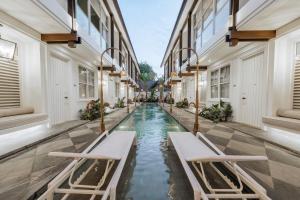 an empty corridor of a building with a pool of water at Nuho Living in Bingin Beach