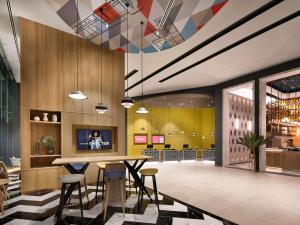 a lobby with a table and chairs in a building at ibis Bangkok Sukhumvit 24 in Bangkok