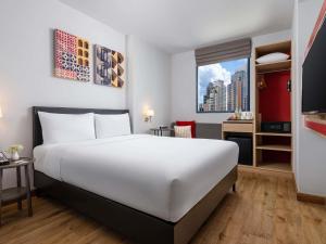 a hotel room with a large white bed and a desk at ibis Bangkok Sukhumvit 24 in Bangkok +28 photos