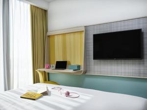 a hotel room with a bed with a flat screen tv at ibis Styles Vung Tau in Vung Tau