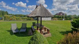 a group of chairs and a table and a umbrella at Pensjonacik Ewa in Darłowo