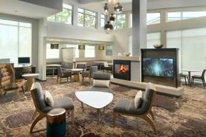 a lobby with a fireplace and chairs and a table at Residence Inn by Marriott Augusta in Augusta