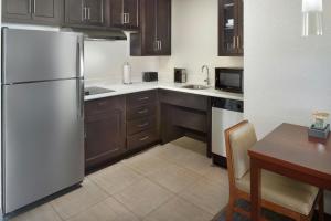 a kitchen with wooden cabinets and a white refrigerator at Residence Inn by Marriott Augusta in Augusta